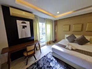 Una habitación de hotel con una cama y un escritorio y un escritorio. en RB9 Oliver's House in Kaset, en Ban Yang