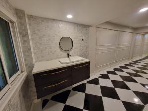 baño con lavabo y espejo en el suelo a cuadros en RB9 Oliver's House in Kaset, en Ban Yang