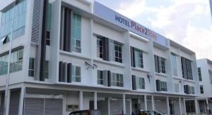 een groot wit gebouw met een bord erop bij Place2stay @ Campus Hub in Kampong Merdang Limau +32 foto's