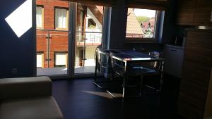 ヤストシェンビャ・グラにあるApartament Latarniaのテーブルと大きな窓が備わる客室です。