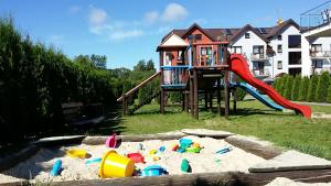 a playground with a play set in the sand at Apartament Latarnia in Jastrzębia Góra