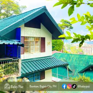 a house with a blue roof and a building at Spacious 2BR Family Home - Narra Unit by Balay Paz in Baguio