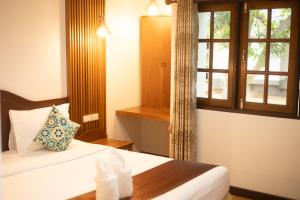 een hotelkamer met een bed en een raam bij CleanWave Resort Chumphon คลีนเวฟ รีสอร์ท in Thung Wua Laen Beach