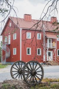 a red barn with two large wheels in front of it at Guesthouse & Caravan Lehtiniemi - Posio in Posio