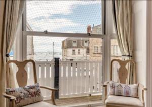 twee stoelen voor een groot raam bij Ocean view in Swanage