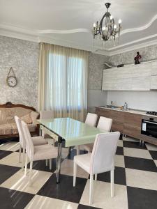 une cuisine et une salle à manger avec une table et des chaises dans l'établissement Riverside Cotagge, à Poti