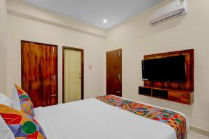 a bedroom with a bed and a flat screen tv at FabHotel Sejour Royal in Chennai