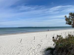 ユリウスルーにあるJuliusruh Bungalow am Strand 16の海を歩く人と砂浜