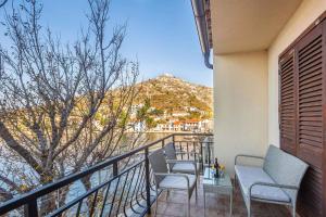 a balcony with two chairs and a view of a mountain at Apartments in Starigrad kod Senja 27140 in Starigrad