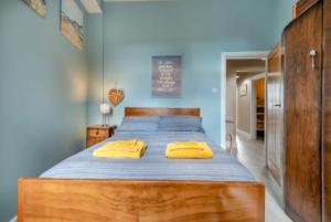 een slaapkamer met een groot bed met gele kussens erop bij Ocean view in Swanage