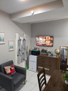 a living room with a couch and a tv on a wall at El Rincón in Tunapuna +49 photos