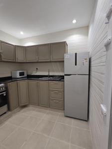 a kitchen with a refrigerator and a microwave at استراحة غوانا 