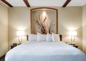 Un dormitorio con una gran cama blanca con dos lámparas. en Luxury Collection Hotel, en Sevan