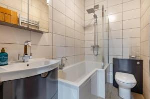 een badkamer met een wastafel, een bad en een toilet bij Ocean view in Swanage +26 foto's