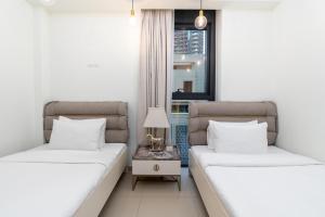 two beds in a room with a window at Westminster ACT1 ACT2 in Dubai +74 photos