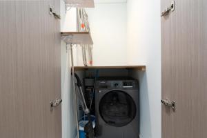a washer and dryer in a bathroom with two doors at Westminster ACT1 ACT2 in Dubai