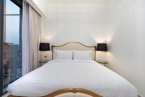 a bedroom with a large white bed and a window at Westminster ACT1 ACT2 in Dubai