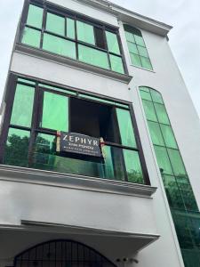 ein Schild in einem Fenster eines Gebäudes in der Unterkunft Zephyr Inn Pondy in Puducherry