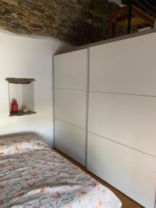 a bedroom with white walls and a bed at Casa Emma in Monteggio