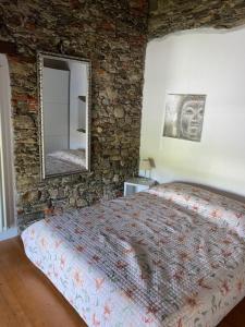 a bedroom with a large bed and a mirror at Casa Emma in Monteggio