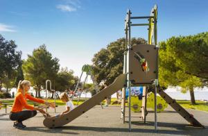 Eine Frau und ein Kind spielen auf einem Spielplatz in der Unterkunft Mobilehomes in Rovinj - Istrien 50060 in Rovinj