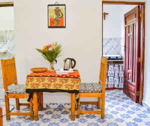ワタムにあるRhino Apartmentsのテーブルと椅子2脚、ティーケトルのあるダイニングルーム