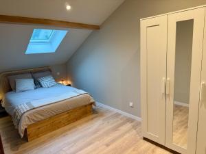 ein Schlafzimmer mit einem Bett und einem Dachfenster in der Unterkunft Au cœur de Morbier in Morbier