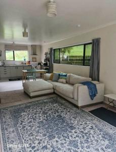a living room with a couch and a table at Peaceful Rural Cottage in Kopuaranga