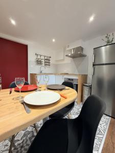a kitchen with a wooden table with chairs and a refrigerator at L'intime in Dingsheim