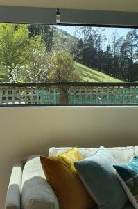 a couch sitting in front of a large window at Peaceful Rural Cottage in Kopuaranga