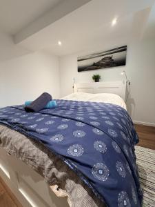 a bedroom with a bed with a blue comforter at L'intime in Dingsheim