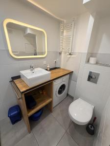 a bathroom with a sink and a toilet and a mirror at L'intime in Dingsheim
