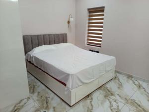 a white bed sitting on top of a marble floor at Oceanus Retreat in Mayyanād +5 photos