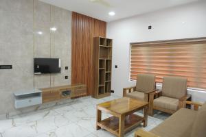 a living room with a tv and a table and chairs at Oceanus Retreat in Mayyanād
