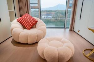 two chairs and a ottoman in a room with a window at 4 RMs city APT, Easy to go all attractions in Zhangjiajie