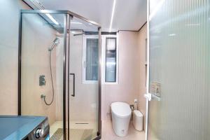 a bathroom with a glass shower and a toilet at 4 RMs city APT, Easy to go all attractions in Zhangjiajie +9 photos