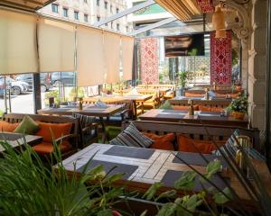 a restaurant with tables and chairs and windows at Alis Business Hotel baku in Baku