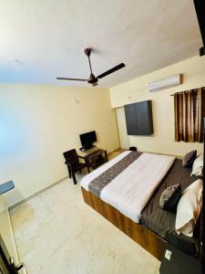 Un dormitorio con una cama grande con ventilador de techo. en Olive By David Residency - Just 4 Kms from Meenakshi Amman Temple, en Madurai