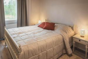 a bedroom with a large bed with a pillow on it at Guesthouse & Caravan Lehtiniemi - Posio in Posio