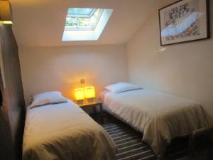 zwei Betten in einem Zimmer mit zwei Lampen und einem Fenster in der Unterkunft Les Olives in Uzès