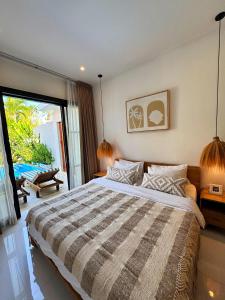 DalungにあるCosy 2bed/2bath villa 5 min to beachの大きなベッドと大きな窓のある寝室