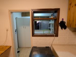 a kitchen with a window in the corner of a room at The Nest in the Tower in Safed