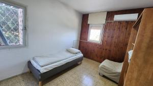 a small room with two beds and a window at The Nest in the Tower in Safed
