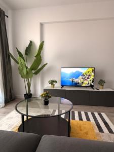 Una sala de estar con un televisor y una mesa. en Rodin Residence-New Apartment with Self Check In, en Colentina