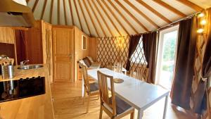 a kitchen with a table and chairs in a tent at Gîte Les yourtes de Saint Mathieu N°1 in Saint-Mathieu +16 photos