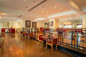 a restaurant with tables and chairs in a room at Metropolitan Al Mafraq Hotel in Abu Dhabi
