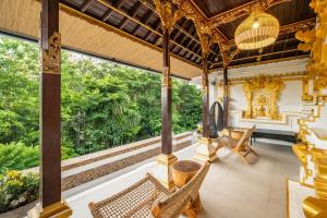 eine Außenterrasse mit Korbstühlen und einem Tisch in der Unterkunft Private Luxe 5BR Swarna Mandapa By Orivista in Uluwatu