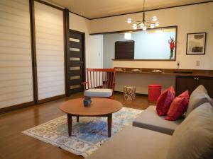 een woonkamer met een bank en een tafel bij ラフィーネハイツ 103 in Fuchu