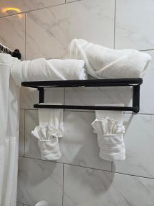 a pile of towels on a towel rack in a bathroom at El Rincón in Tunapuna