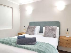 een slaapkamer met een bed met een groen hoofdeinde en kussens bij Ocean Blue Stay in St James